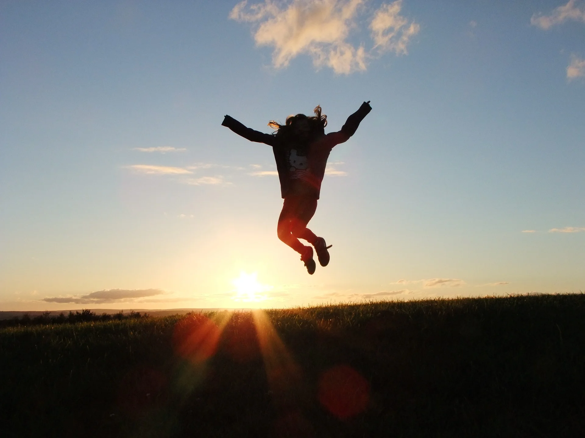 Person jumping for joy in front of sunset