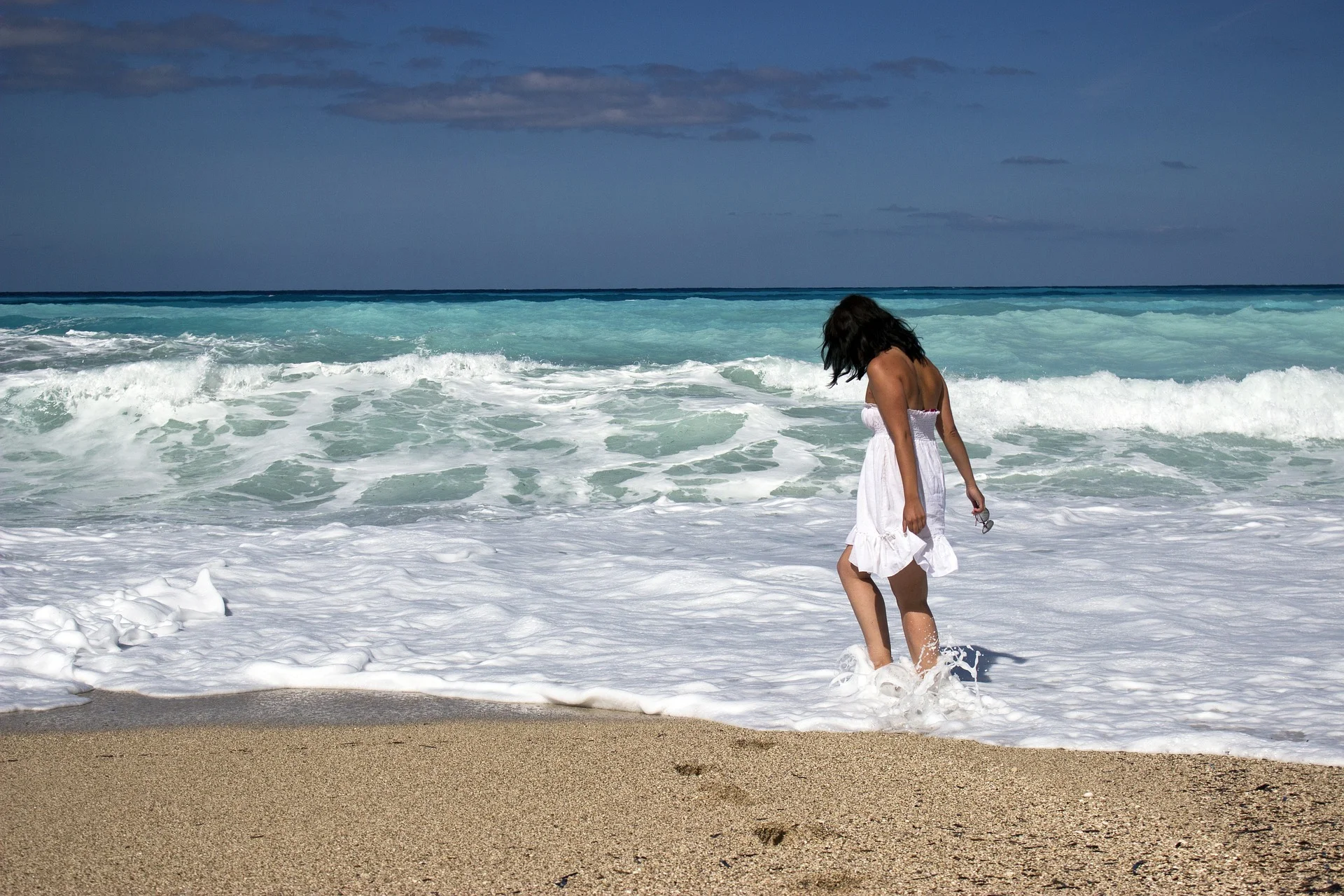 Woman walking in the surf on a beach