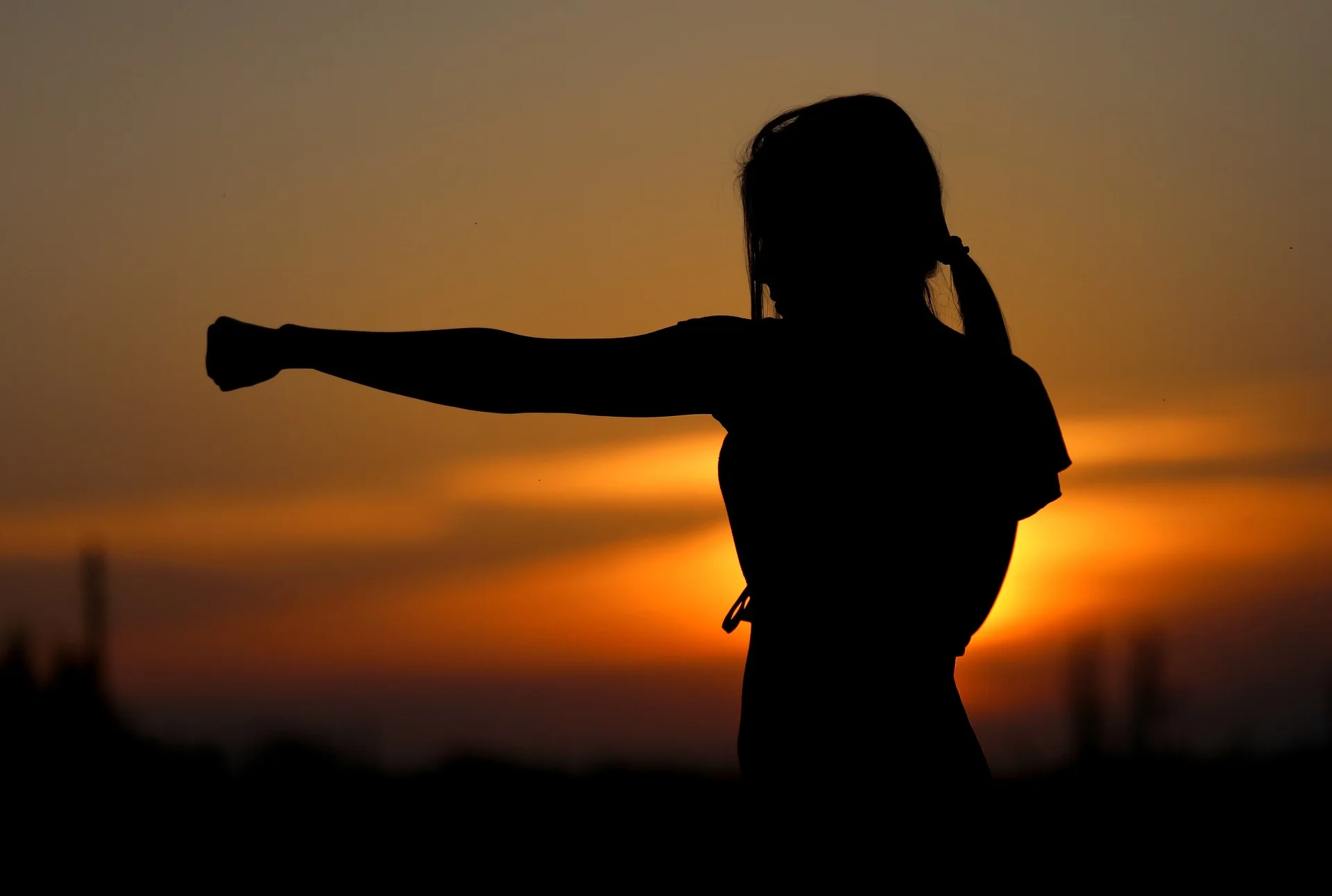 Silhouette of woman punching the air