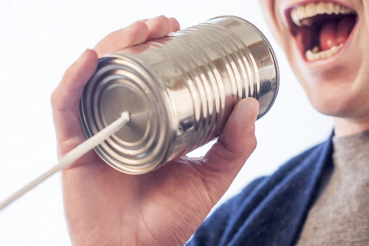Person yelling through tin can telephone