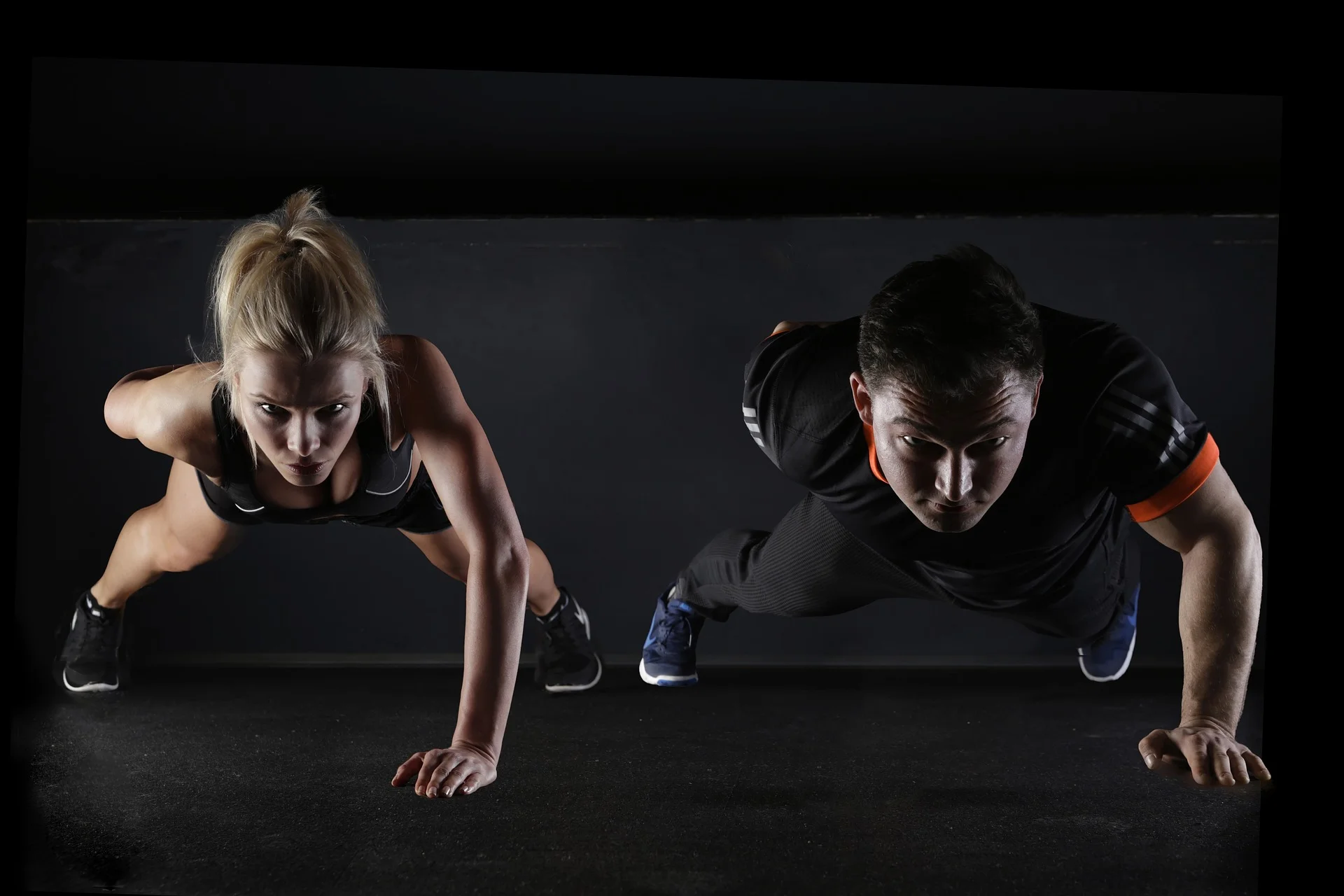 Man and woman doing one arm pushups