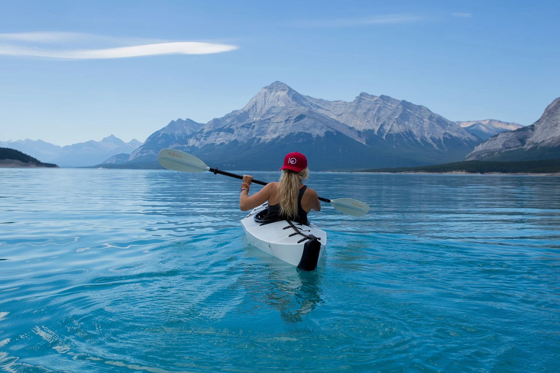 Woman in sea kayak with mountain background