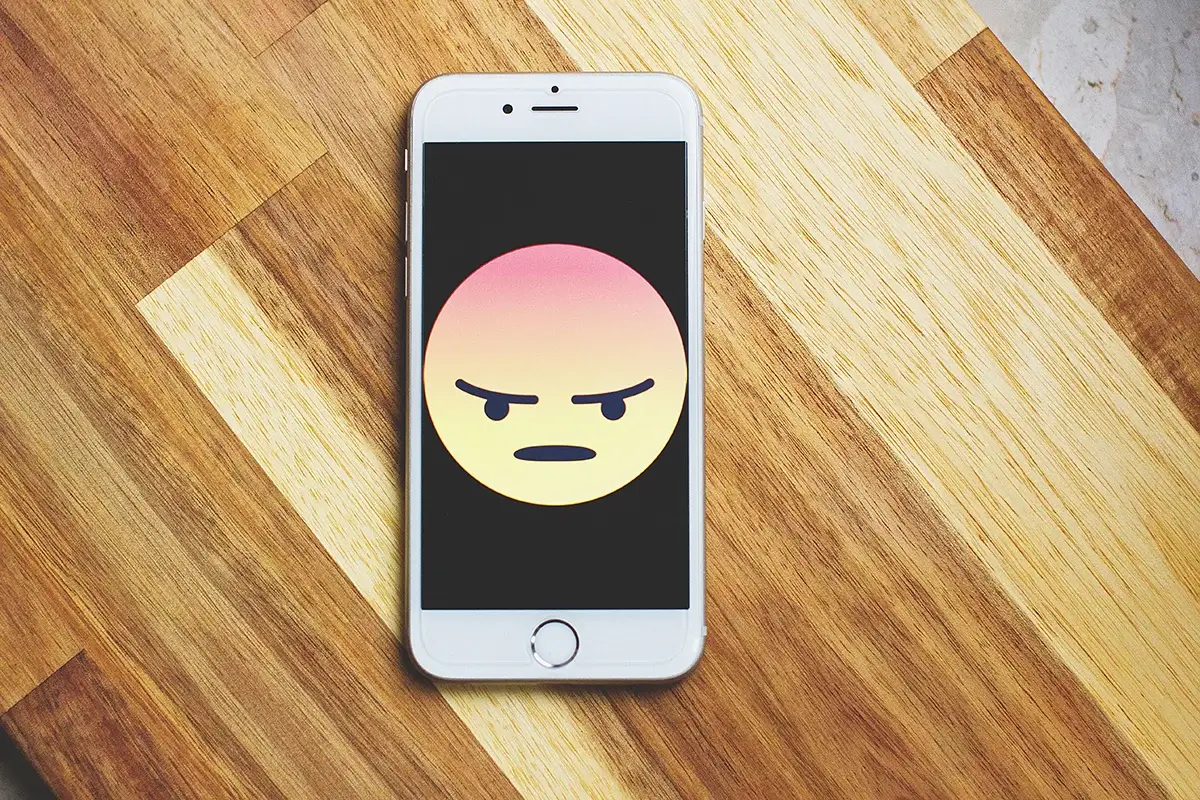 Cell phone with angry emoji on the screen