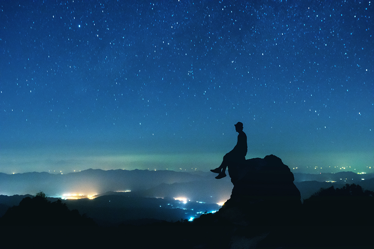 Silhouette of person in front of night sky